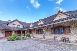 a large stone building with a patio in front of it at Jaś i Małgosia in Poraj