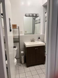 uma casa de banho com um lavatório, um WC e um espelho. em NY3182-9 Private Office w Double SofaBed Keypad em Unionport