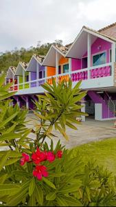 a row of colorful houses with flowers in front at Pousada Linda Vista in Domingos Martins