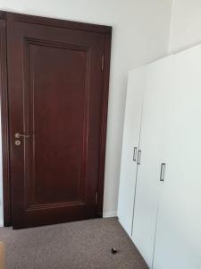 uma porta castanha num quarto com um armário em Madera House em Katowice
