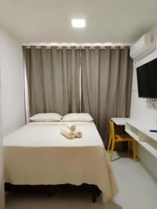 a bedroom with a bed with two teddy bears on it at Compact Tambaú 408 in João Pessoa