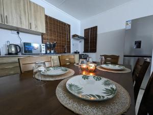 una cocina con una mesa con platos y vasos. en Blissful Abode GV, en Grand Gaube