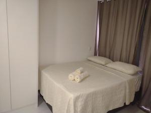 ein Bett mit zwei gewalzten Handtüchern darüber in der Unterkunft Compact Tambaú 408 in João Pessoa