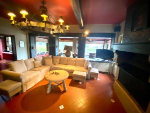 ein Wohnzimmer mit einem Sofa und einem Tisch in der Unterkunft Luxury Spa Gîtes - Luxury Chalet Warfaaz in Jalhay