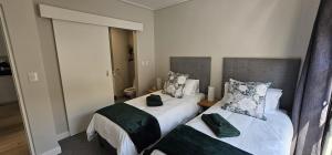 a bedroom with two beds and a mirror at 116 The Esplanade in Hermanus +18 photos