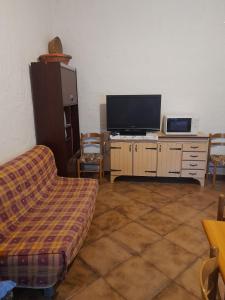 sala de estar con sofá y TV de pantalla plana en Casa vacanza bel vedere, en Villamassargia