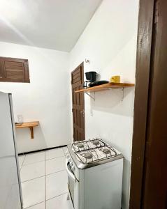 a small kitchen with a stove and a refrigerator at Pousada Apart Amor de Jeri in Jericoacoara