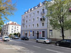 biały budynek po stronie ulicy w obiekcie Apartament Akali w Kielcach