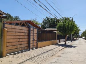 uma cerca de madeira ao lado de um passeio com uma árvore em Casa Los Andes em Los Andes