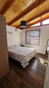 1 dormitorio con 1 cama en una habitación con techo de madera en Casa Los Andes en Los Andes