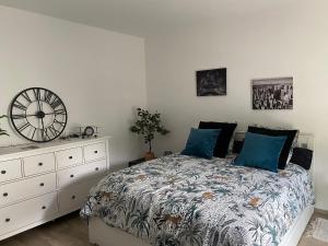 a bedroom with a bed and a clock on the wall at Studio Moderne Tout équipé Wifi - Parking gratuit - Proche de la Nature in Wissembourg
