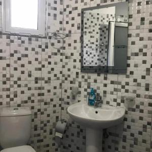 un bagno con lavandino, water e specchio di Guesthouse Noan&Yliona a Ksamil