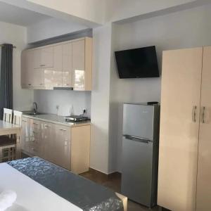 una cucina con armadietti bianchi e frigorifero nero di Guesthouse Noan&Yliona a Ksamil Altre 37 foto