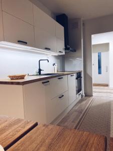 uma cozinha com armários brancos e um lavatório em Moderni huoneisto Salon keskustassa em Salo