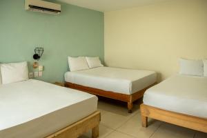 2 Betten in einem Zimmer mit 2 weiteren Stellenangeboten in der Unterkunft Hotel Paso del Mar Playa del Carmen in Playa del Carmen