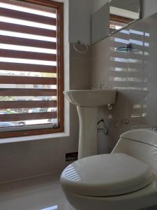 a white bathroom with a toilet and a sink at La Preferida in Lima
