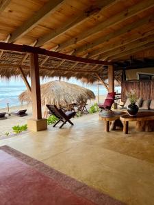 Posada Mexico في زيبوليت: جناح مع كراسي وطاولات على الشاطئ