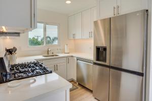 a kitchen with white cabinets and a stainless steel refrigerator at Ocean-View Oasis Steps to Dana Point Beaches! in Dana Point