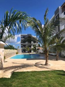 uma palmeira sentada ao lado de uma piscina em Sol Caribe 101 Bayahibe con linda piscina! em Bayahibe