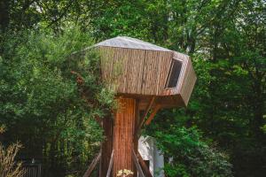 una casa en el árbol sentada en la parte superior de un árbol en Utopia Village - Art & Nature Lodges, en Jurbise