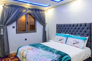 ADAM APPARTEMENTS في دخلة: غرفة نوم مع سرير بسقف ازرق