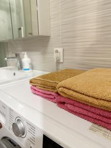 una pila de toallas sobre una lavadora en Апартаменты в ЖК Аманат, en Almaty