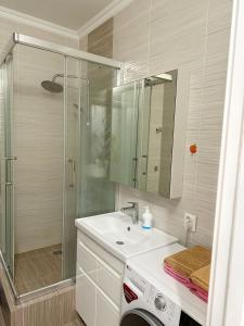 y baño blanco con lavabo y ducha. en Апартаменты в ЖК Аманат, en Almaty