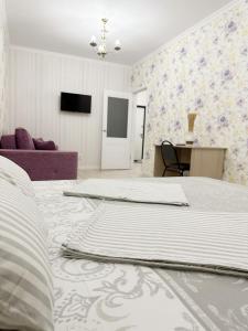 1 dormitorio con 1 cama grande y 1 mesa en Апартаменты в ЖК Аманат, en Almaty