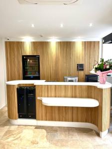 a lobby with a reception desk with a vase of flowers at VLH Montparnasse Eiffel in Paris