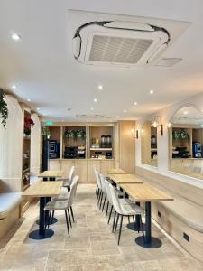um restaurante com mesas de madeira e cadeiras brancas em VLH Montparnasse Eiffel em Paris