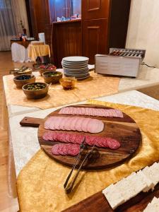 três pedaços de carne numa tábua de cortar numa mesa em Hotel Bavaria em Craiova