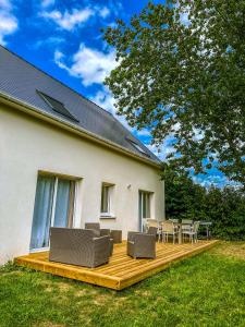 una terraza de madera con sillas y una mesa en una casa en Le cocon de Normandy, en Criquebeuf-sur-Seine