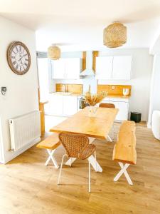 cocina y comedor con mesa de madera y sillas en Le cocon de Normandy, en Criquebeuf-sur-Seine