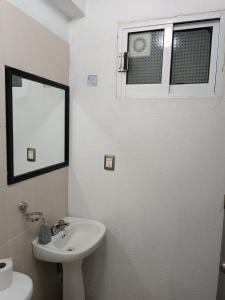 a white bathroom with a sink and a mirror at Departamento allende antiguo in Oaxaca City