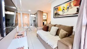 uma sala de estar com um sofá e uma mesa em Eco Summer Tambaú - Apartamentos de 2 Quartos por Genius Flats em João Pessoa