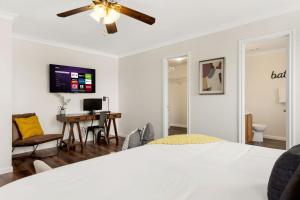 a bedroom with a bed with a ceiling fan and a desk at Private Heated Pool & Hot Tub, 4BR Gameroom in San Antonio