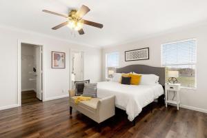 a white bedroom with a bed and a ceiling fan at Private Heated Pool & Hot Tub, 4BR Gameroom in San Antonio