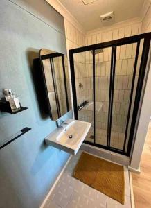 Un baño con lavabo y ducha con espejo. en Blouberg Studio, en Ciudad del Cabo