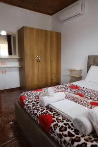 een slaapkamer met een bed met handdoeken erop bij Villa Rexho in Berat