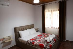 een bed met twee teddyberen erop in een slaapkamer bij Villa Rexho in Berat