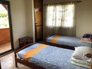 1 dormitorio con 2 camas individuales y ventana en Finca hotel boutique en el peñol, en Guatapé