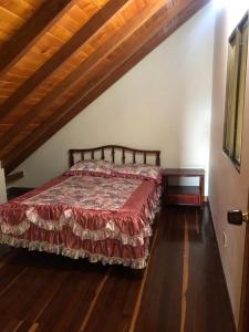 1 dormitorio con 1 cama y suelo de madera en Finca hotel boutique en el peñol, en Guatapé