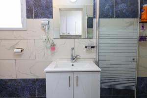 Un baño con un lavabo blanco y un espejo. en דירת אירוח vip רק 5 דקות נסיעה מהים חלום של מקום, en Ashkelon