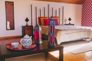 Schlafzimmer mit einem Bett mit Vasen auf einem Tisch in der Unterkunft Casas de Campo Villa D'Almeida in Travancinha
