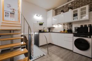 uma cozinha com armários brancos e uma máquina de lavar e secar roupa em Old Town WAWEL II Premium Apartment – 52m2 em Cracóvia