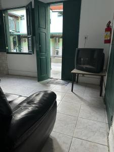 a living room with a couch and a tv at Pouso dos Viajantes Unidade Centro OuroPreto in Ouro Preto