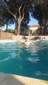 a man is swimming in a swimming pool at Casas de Campo Villa D'Almeida in Travancinha