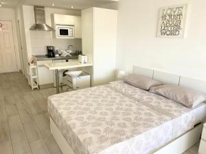 una camera con un grande letto e una cucina di TOP FLOOR, Panoramic Studio, Heated Pool a Los Cristianos