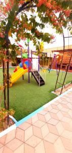 a playground with a slide in a park at كيان ( KAYAN) in Sūr ash Shiyādī