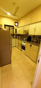 a large kitchen with a refrigerator and a tiled floor at كيان ( KAYAN) in Sūr ash Shiyādī